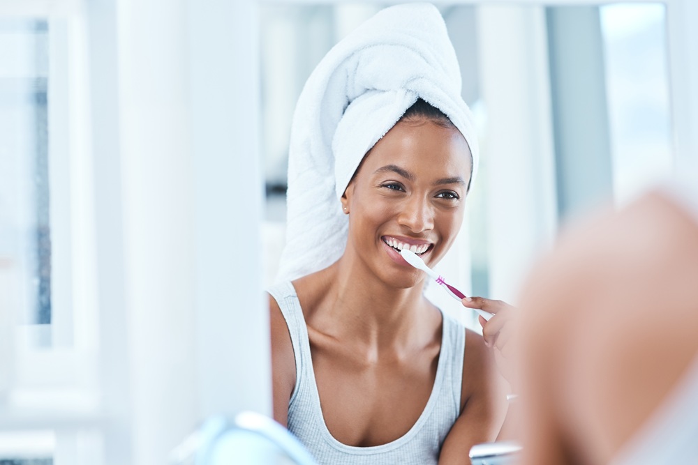 A woman practicing good oral hygiene by brushing her teeth, emphasizing the importance of daily dental care habits – Dentist in Torrance CA.