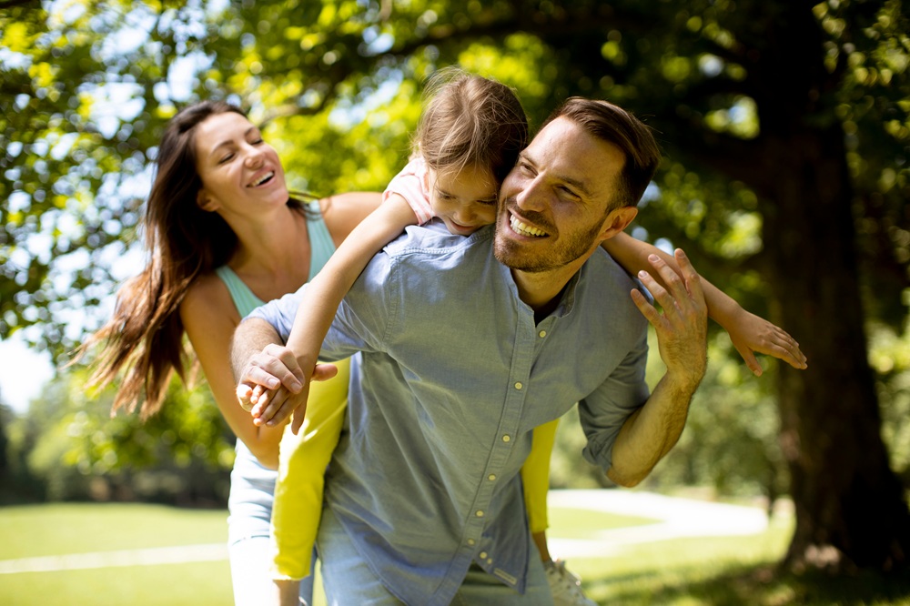 A joyful family shares laughter outdoors, highlighting bright, healthy smiles made possible through preventive and comprehensive dental care - Dentist in San Pedro CA