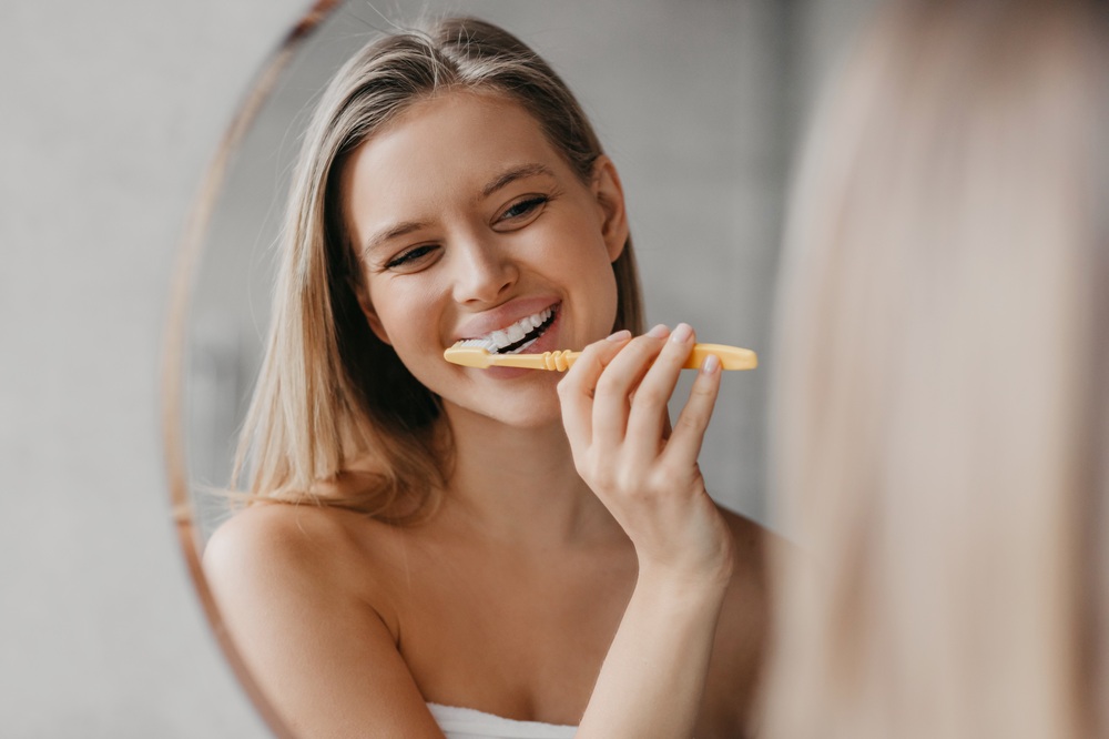 Daily Toothbrushing Routine for Healthy Smile – Preventative Dentistry in Redondo Beach A woman brushes her teeth at home as part of a consistent oral care routine that supports professional preventative dental services. – Preventative Dentistry in Redondo Beach