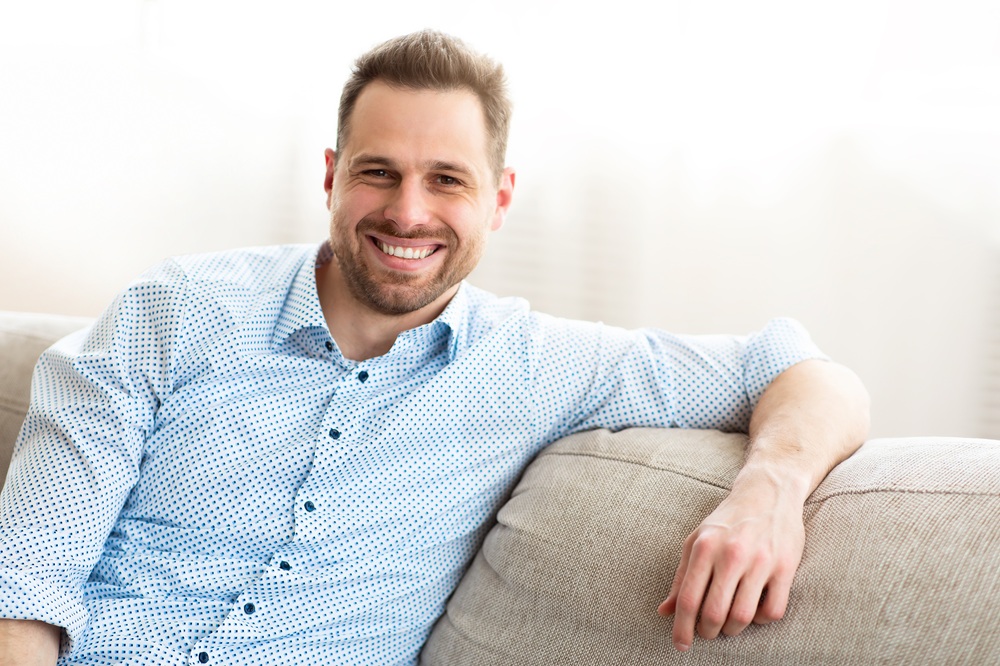 A professional adult man smiling brightly, showcasing the results of preventive and cosmetic dental treatments for a healthy smile – Dentist in Redondo Beach.