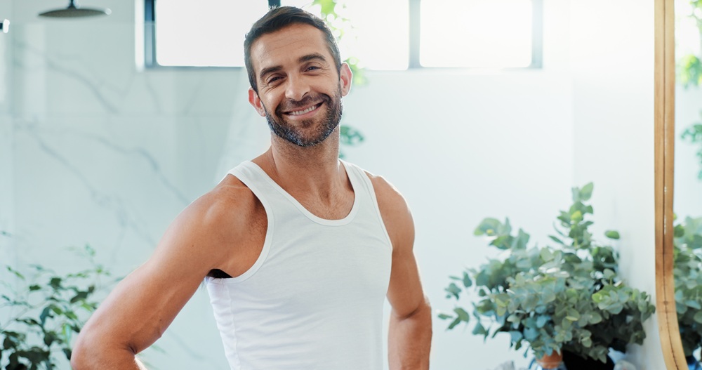 A middle-aged man smiling confidently in a bright setting, reflecting the results of consistent oral hygiene and routine dental cleanings – Redondo Beach Dental Cleanings