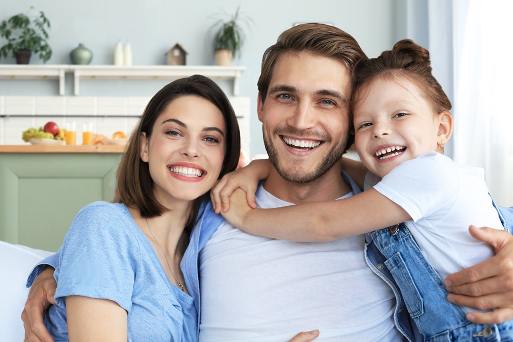 A joyful family shares confident smiles in a cozy home setting, highlighting the importance of preventive and comprehensive dental care for all ages - Dentist in San Pedro CA