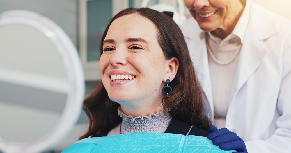 A happy female patient smiles confidently after a professional dental cleaning appointment, showcasing bright, healthy teeth in a modern dental office setting. – Dental Cleaning in Torrance CA