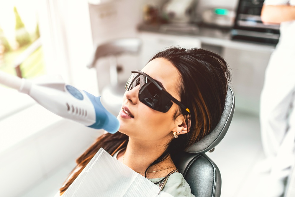 A woman undergoing advanced laser dental treatment while wearing protective eyewear, highlighting modern dental technology – Dentist in Redondo Beach.