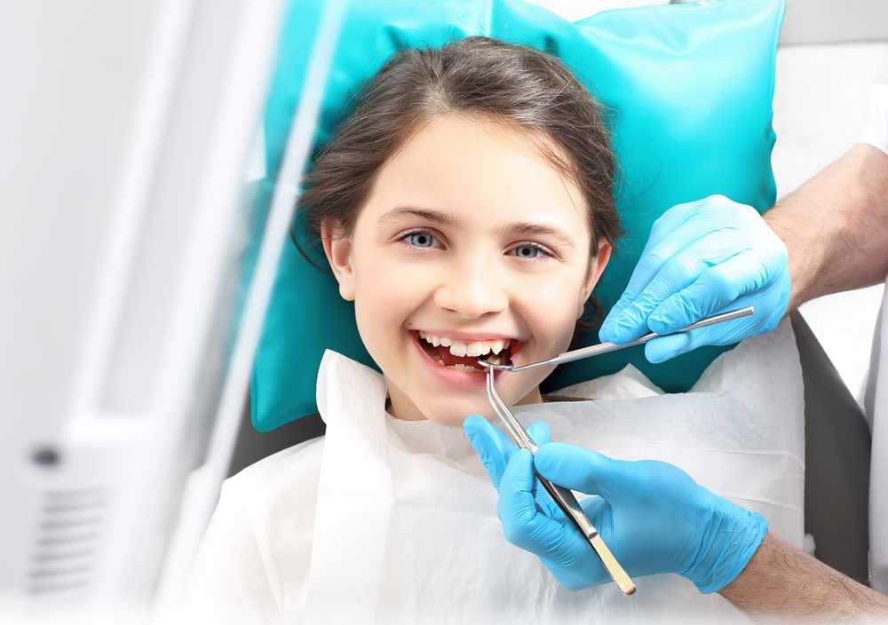 A young girl smiling during a dental visit, reflecting gentle pediatric dental care in a friendly environment – Dentist in Redondo Beach.