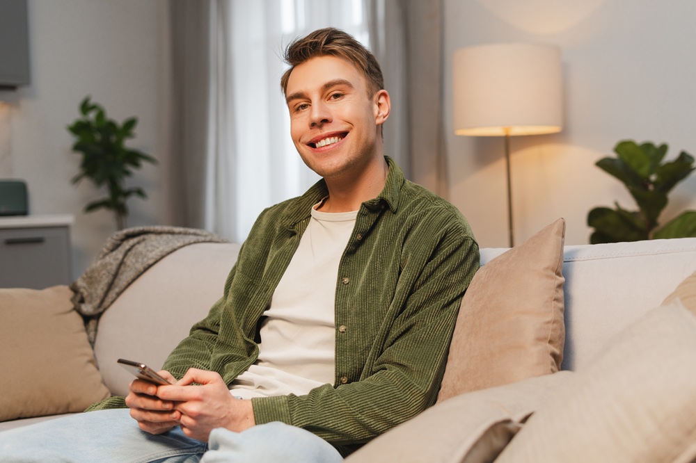 Smiling Patient Scheduling Dental Visit Online – Preventative Dentistry in Redondo Beach A happy patient relaxes at home while booking a dental appointment online, highlighting the importance of routine checkups and proactive oral health care. – Preventative Dentistry in Redondo Beach